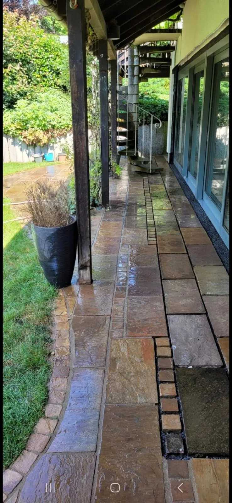 Plattenweg zwischen Gebäudefassade und Garten