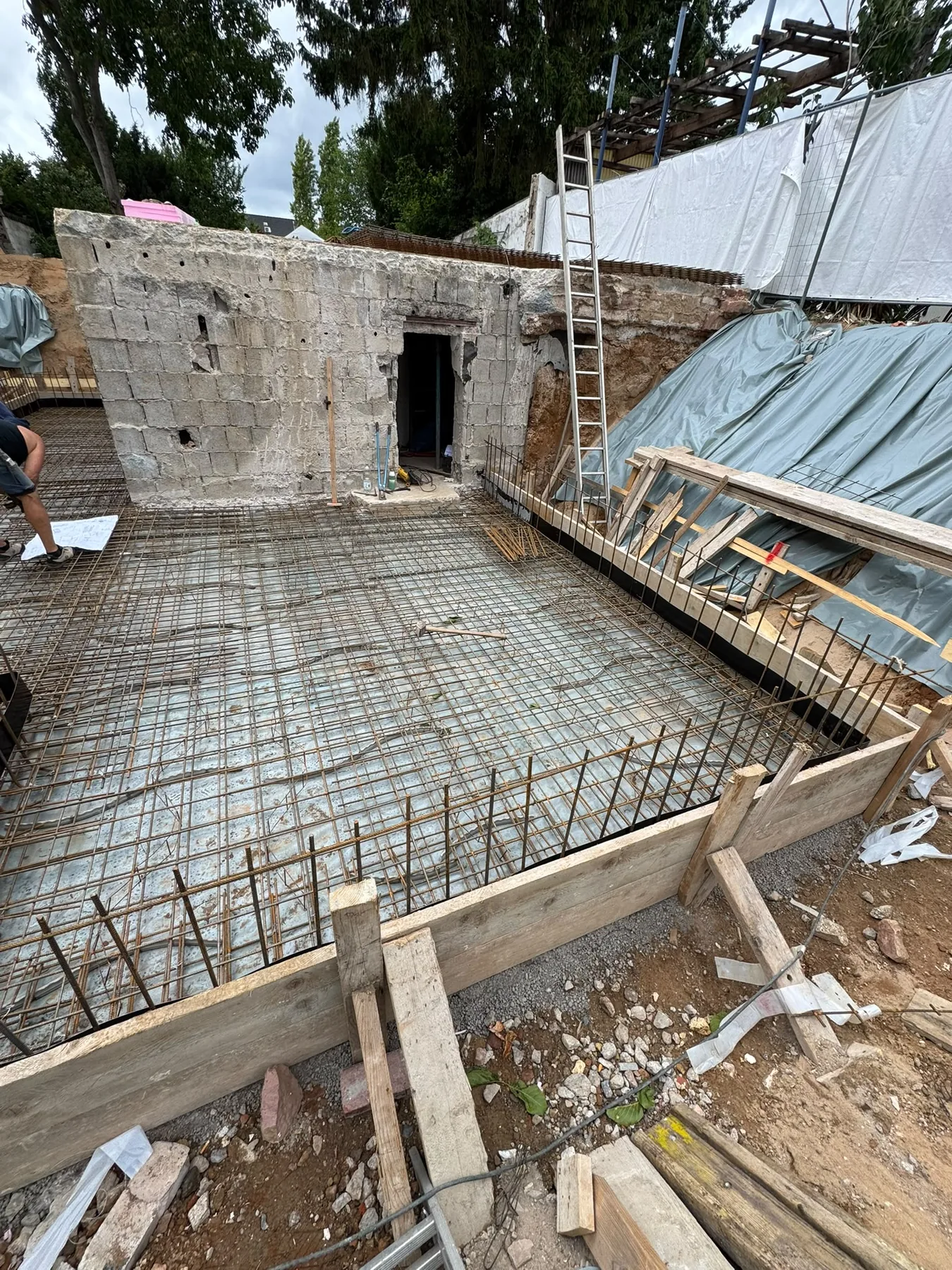 Bewehrungsmatten und Holzschalung vor einer bestehenden Mauer