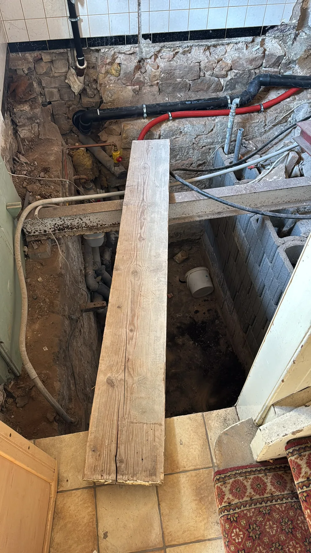 Geöffneter Boden mit Leitungen und Holzbrettern